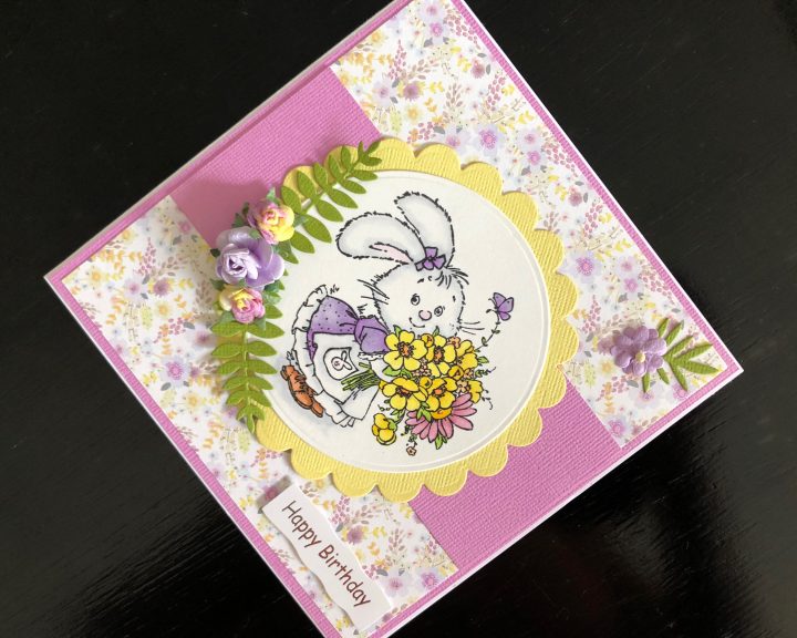 Hand made birthday card with a stamped rabbit image and spring flowers