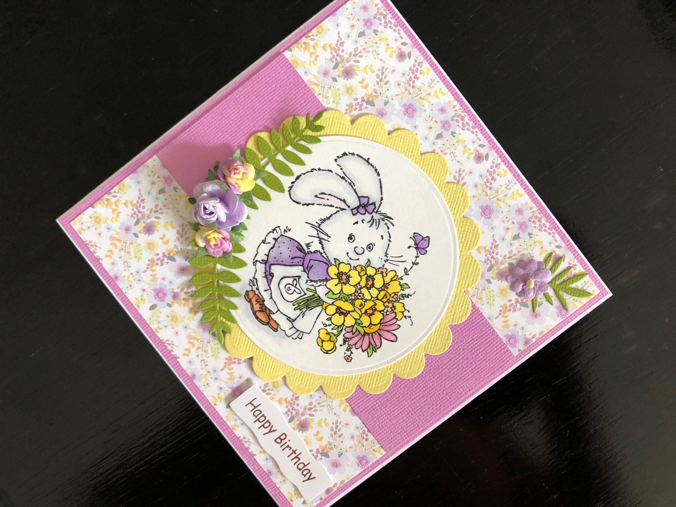 Hand made birthday card with a stamped rabbit image and spring flowers