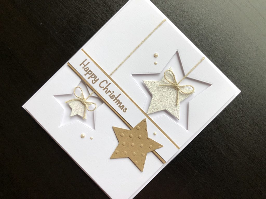 Hand made Christmas card with die cut stars and heat embossing.
