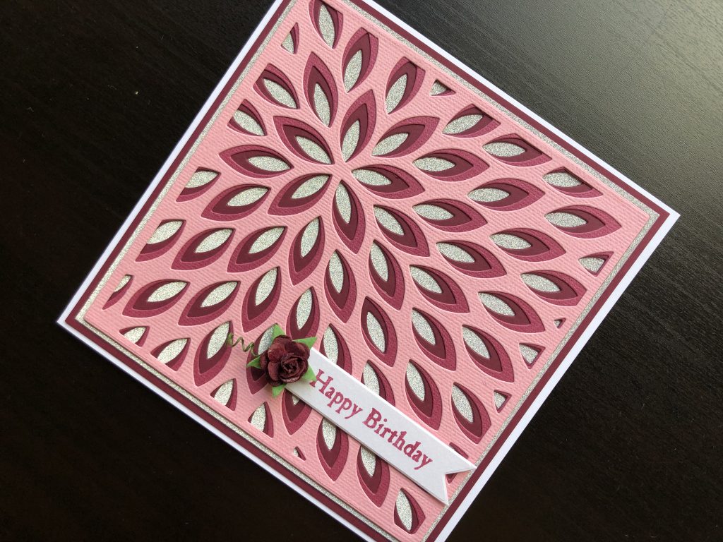 Hand made birthday card with layered die cutting, and paper rose embellishment.