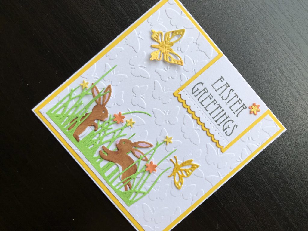 Hand made Easter card with die cut rabbits and flower border.