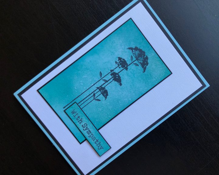 Sympathy card with silhouette stamped flower on a Distress Oxide background