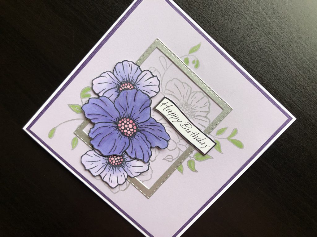 Hand made birthday card with stamped flowers and die cut frame.
