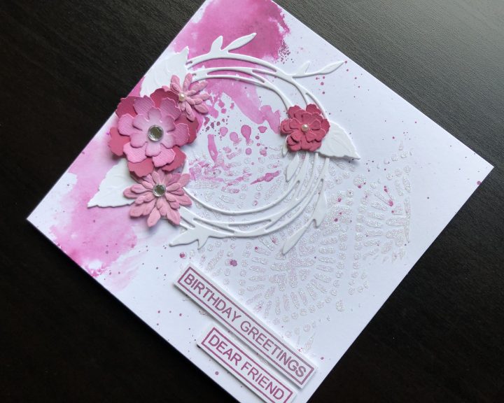 hand made birthday card with die cut wreath and flowers and stencilled glitter paste background