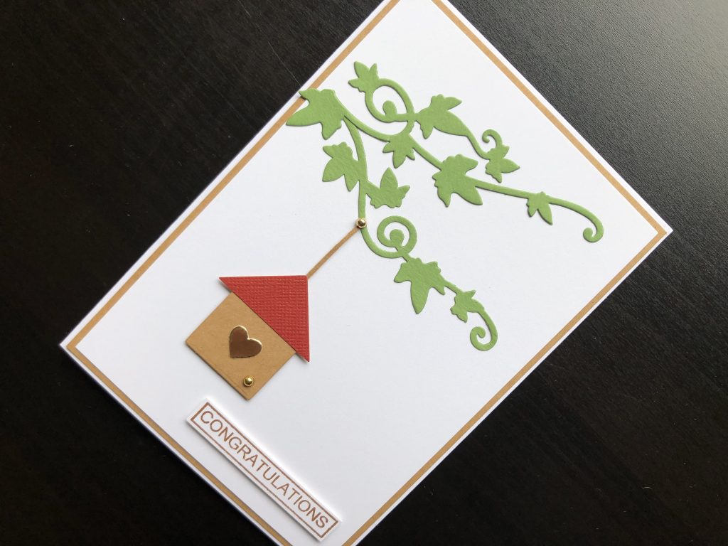 Hand made new home card with die cut branches and bird house and stamped congratulations greeting.