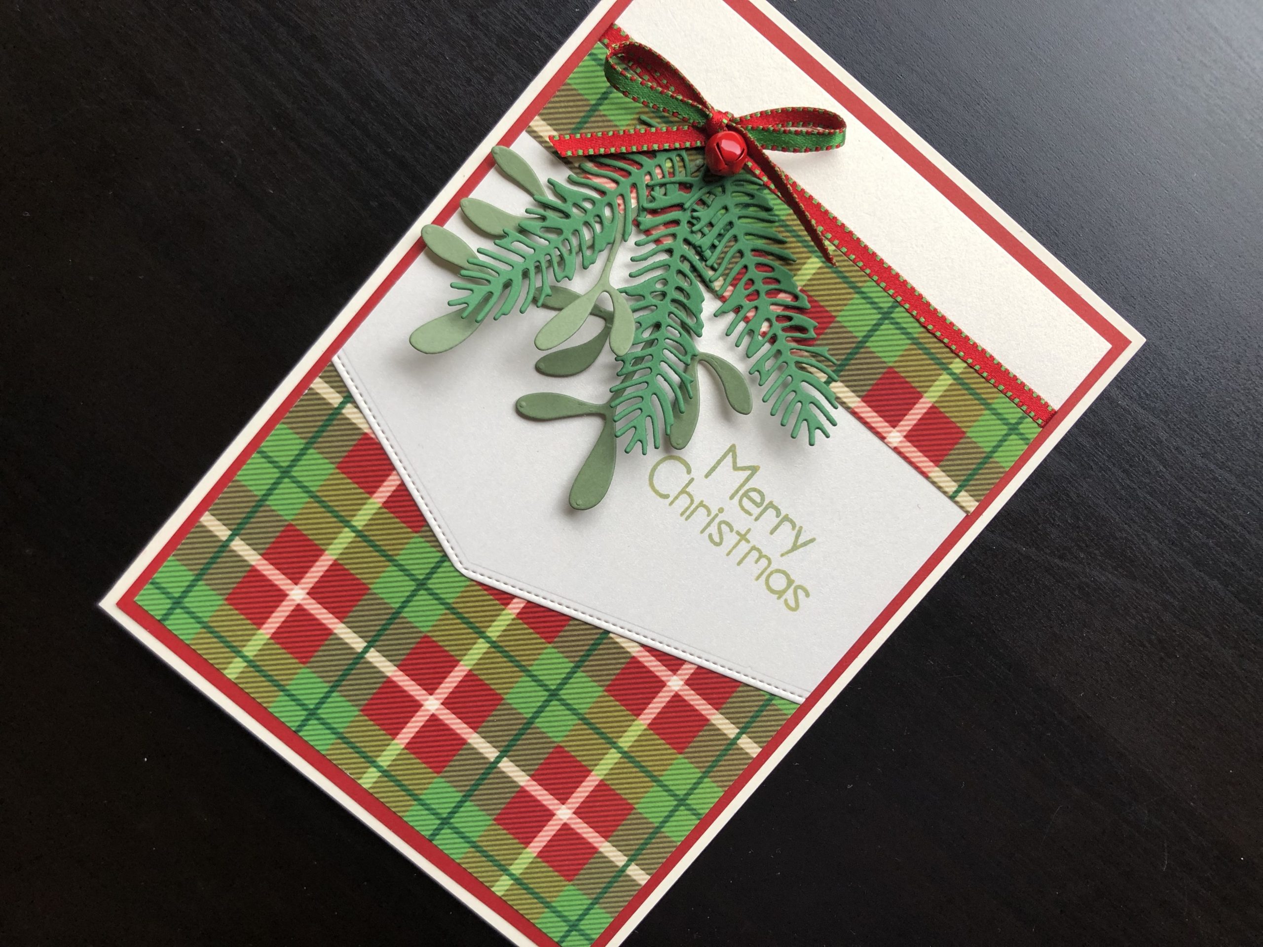 hand made Christmas card with die cut pine and mistletoe branches and tartan background