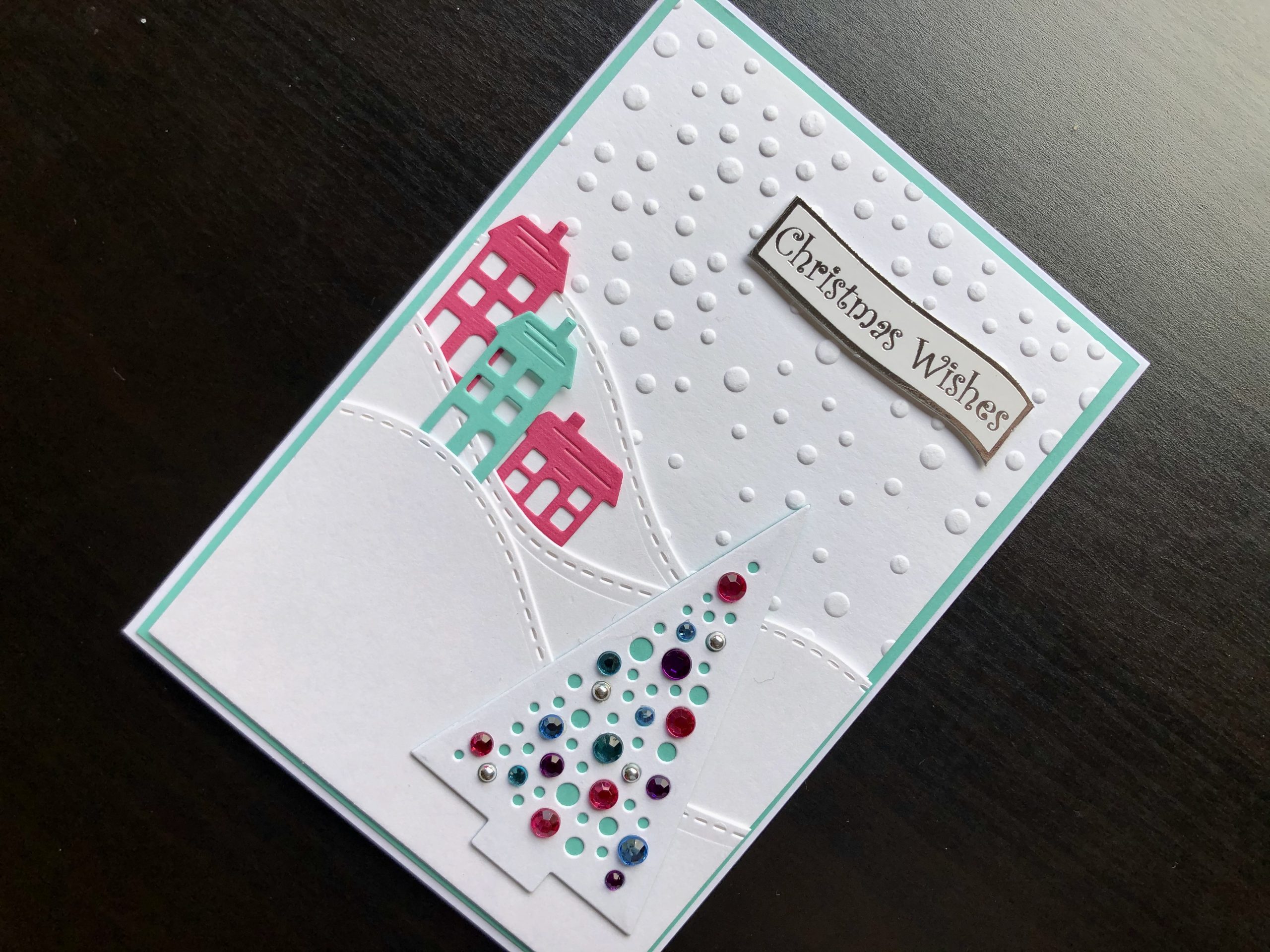 Hand made Christmas card with embossed snowfall background and jewel decorated tree