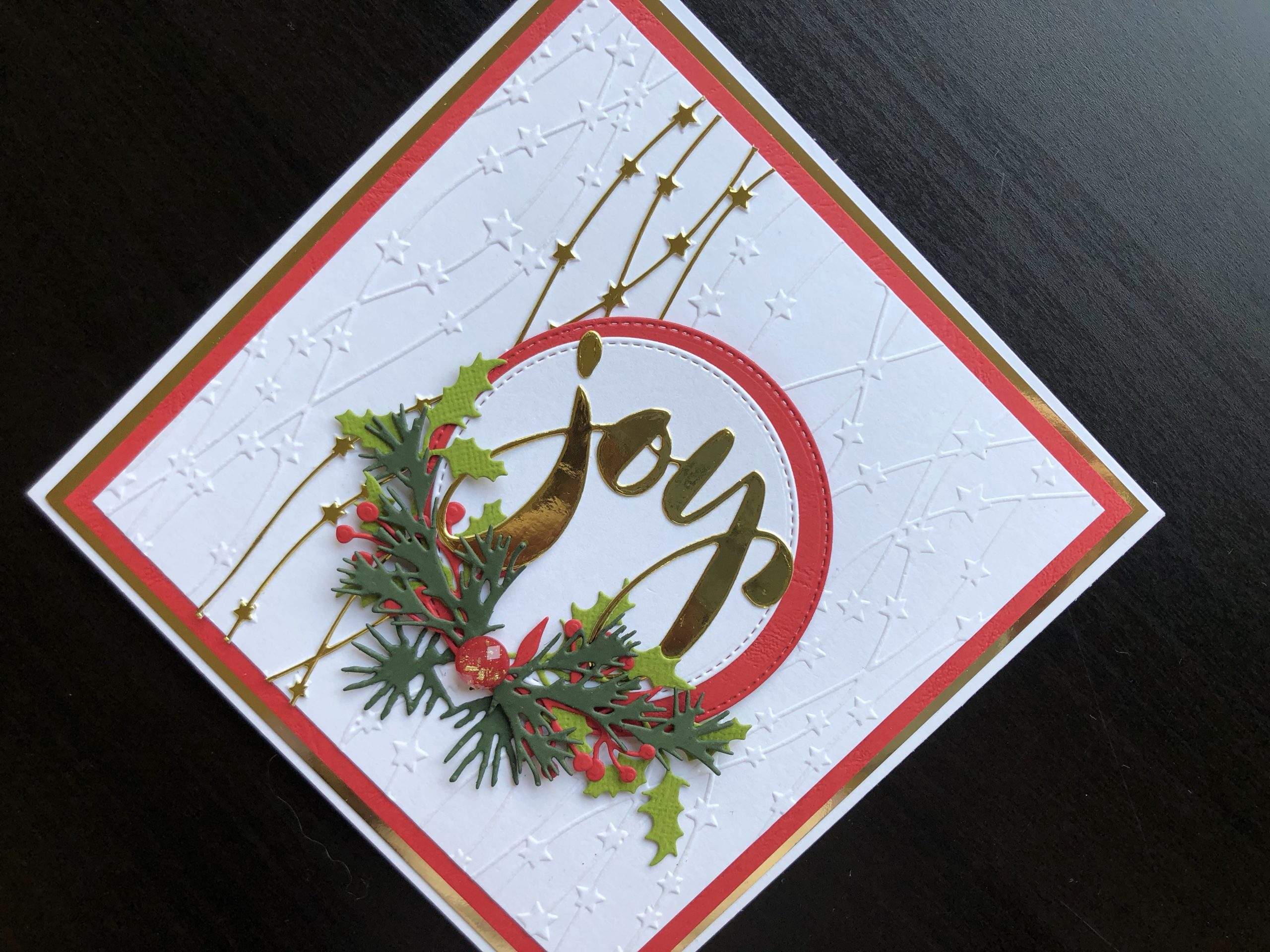 Hand made Christmas card with die cut sentiment and foliage and embossed background