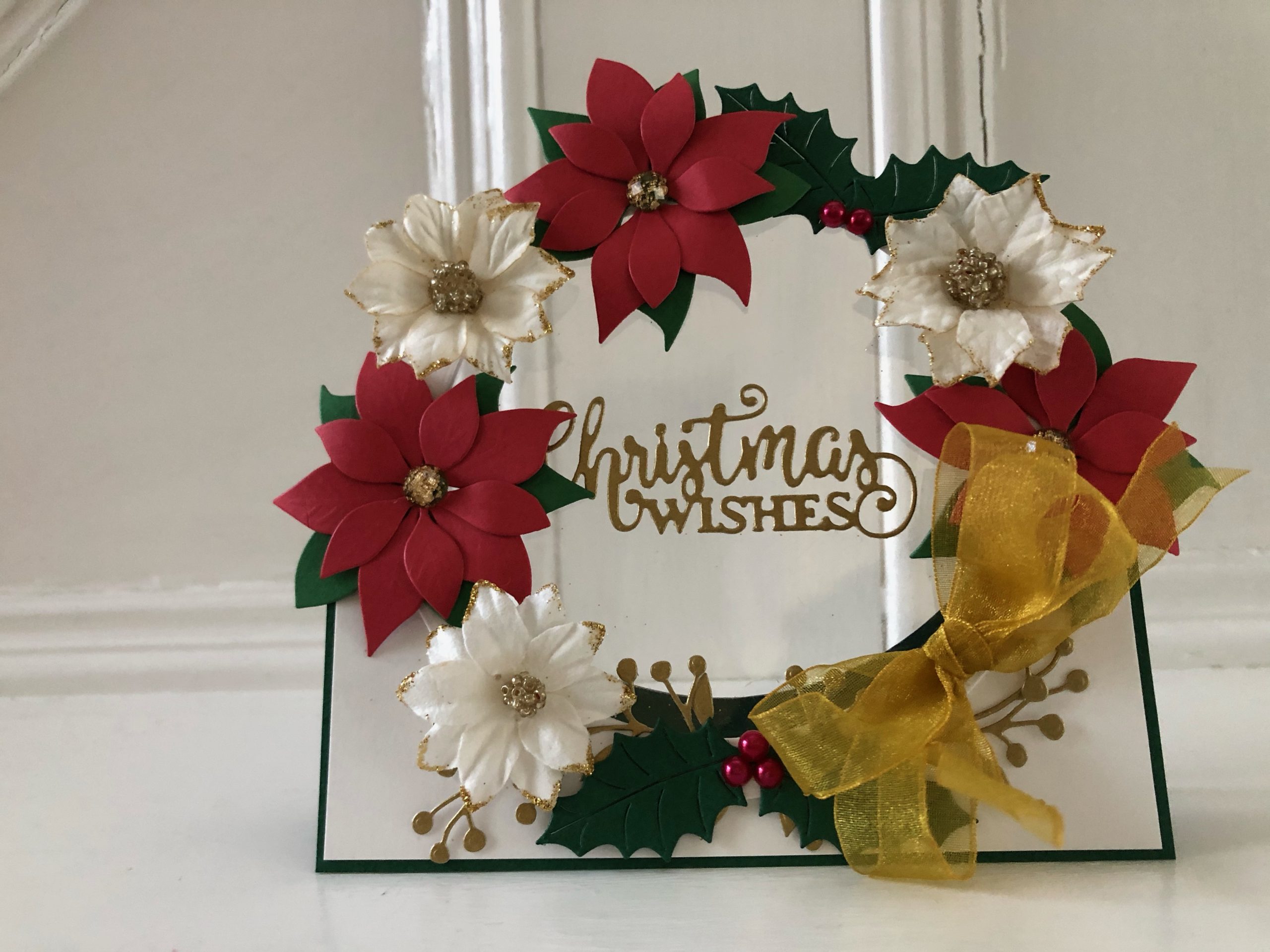 hand made christmas card with flower and holly wreath