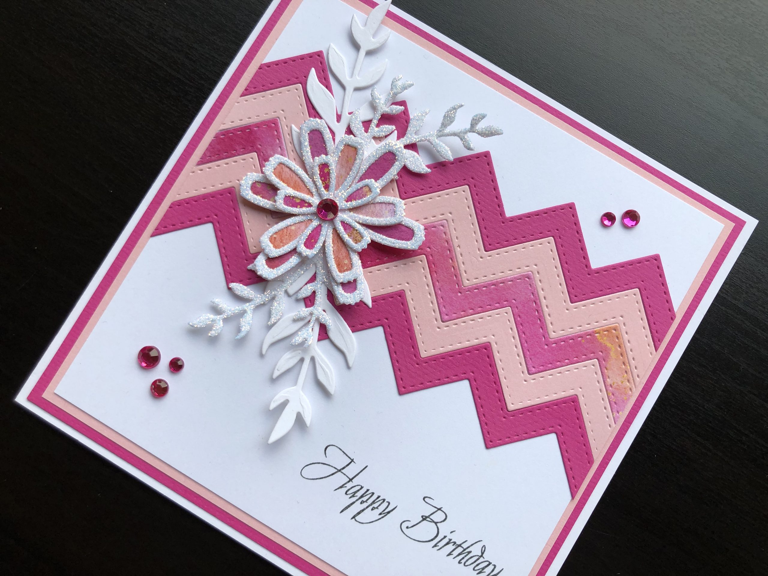 Hand made birthday card with die cut zigzag panel, flowers and leafy stems