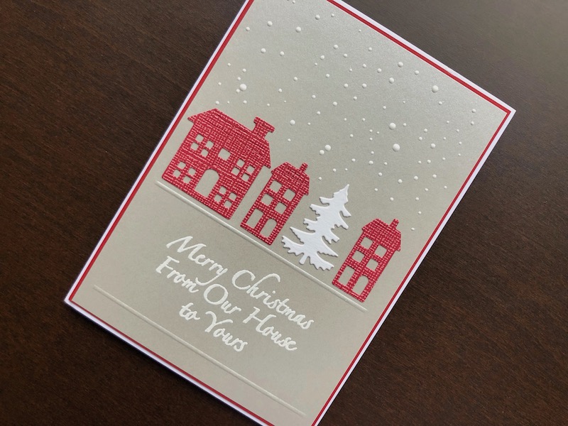 Hand made Christmas card with die cut houses and stamped and heat embossed sentiment