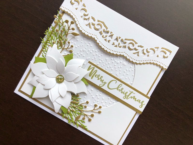 Hand made Christmas card with white die cut poinsettia and embossed snowfall background