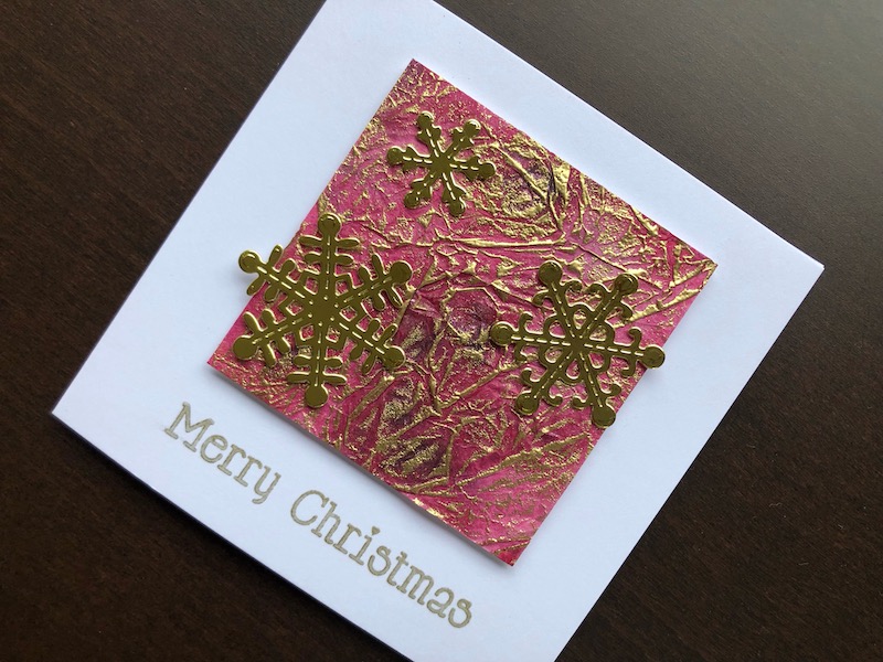 Hand made Christmas card with inked tissue panel and die cut snowflakes