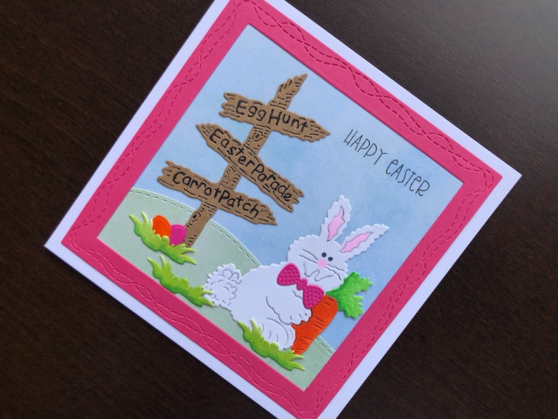 Hand made Easter card with die cut bunny and sign post and frame with wonky stitch lines.