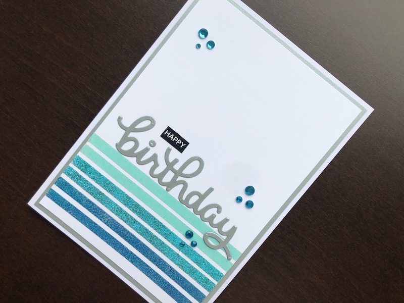 Hand made birthday card with stripes of heat embossed double sided tape and die cut birthday.
