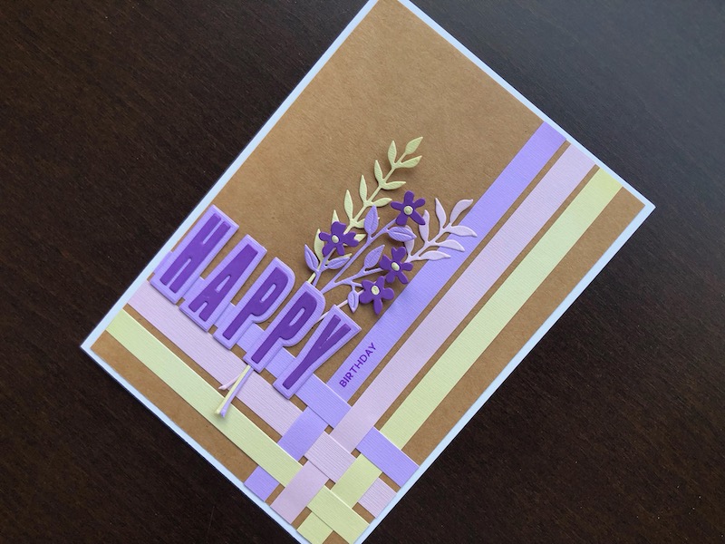 Hand made birthday card with woven paper strips, die cut and stamped sentiment and die cut flowers.