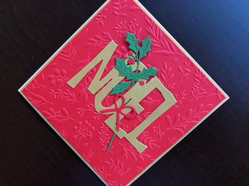 Hand made Christmas card with die cut Noel and holly and embossed branches and berries background.