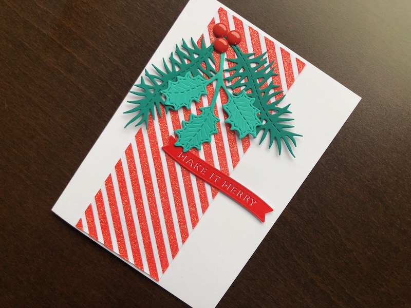 Hand made Christmas card with stencilled glitter paste stripes, and die cut winter foliage and sentiment.