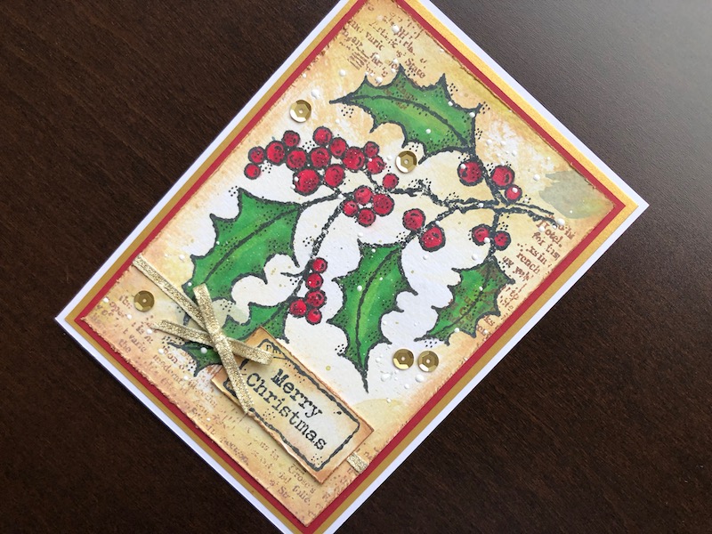 Hand made vintage style Christmas card with distressed ink background and stamped and coloured holly spray.