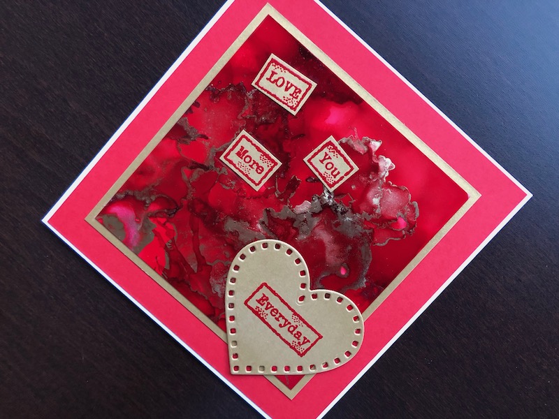 Hand made Valentine card with red and gold alcohol ink background, red and gold sentiments and die cut heart.
